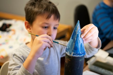 boy painting rocket ship craft