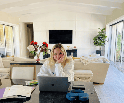 A feemale High school student working on a computer in her living room.