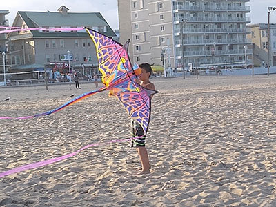 a boy flying a kite at the beach